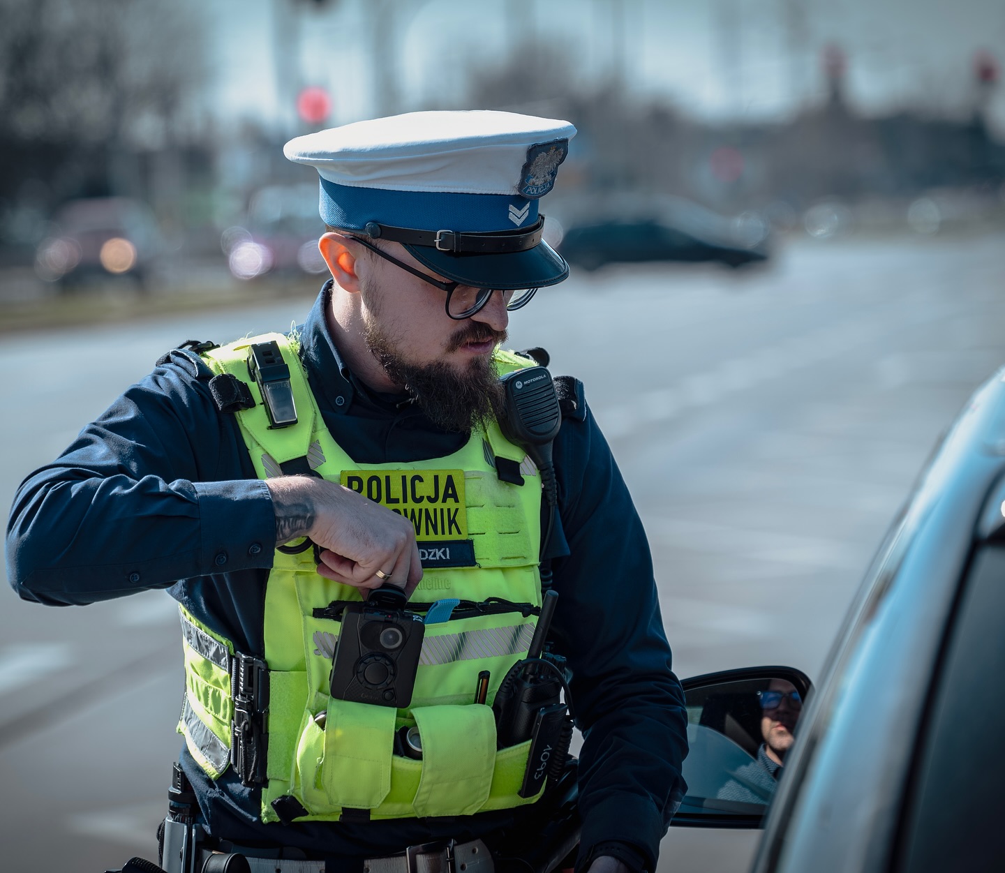 Policjant wydziału ruchu drogowego podczas służby w kamizelce Hold The Line